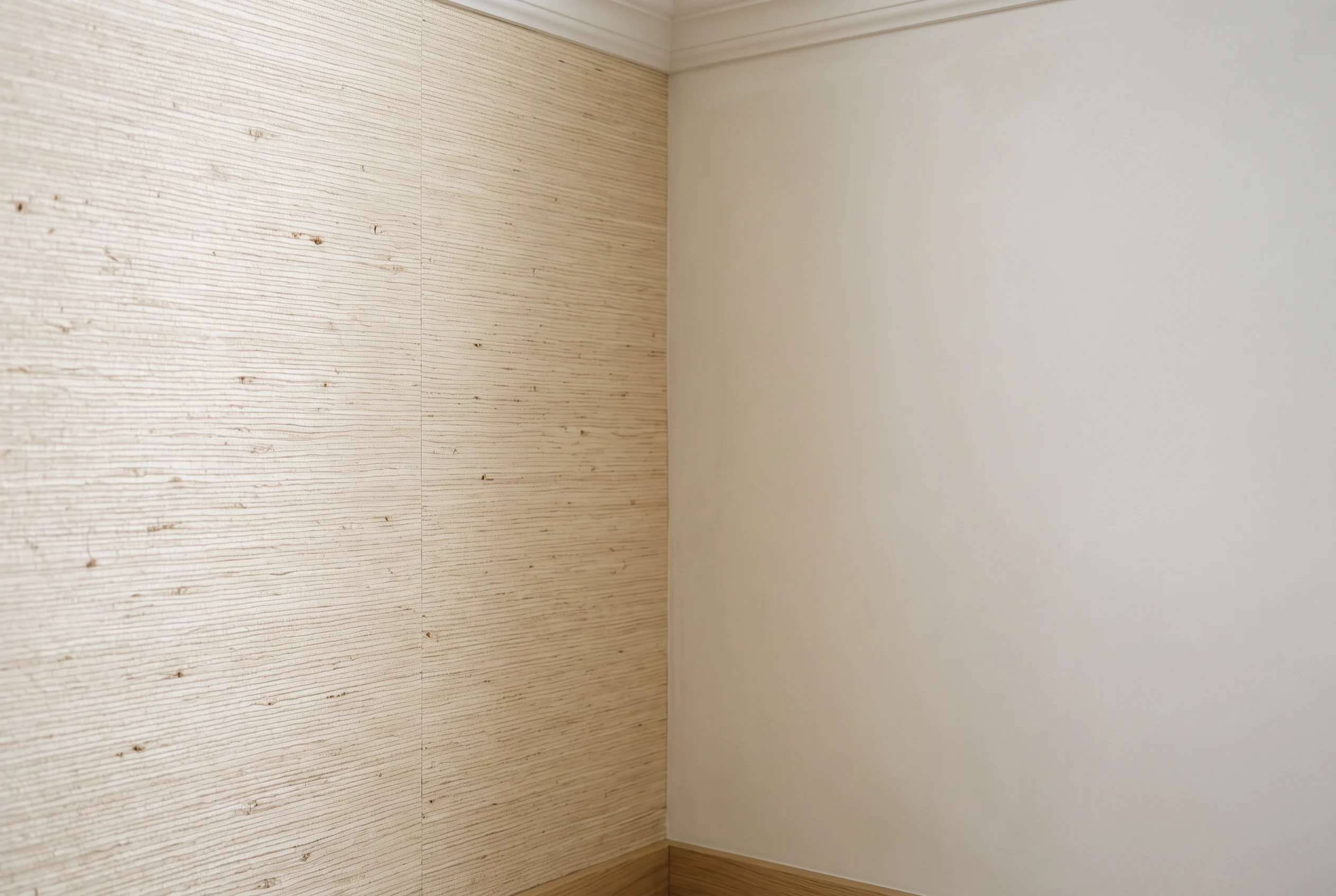 A smooth prepared wall meeting a neatly finished grasscloth wallpaper section